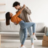 casal no centro de uma sala em movimento como se eles estivessem dançando
