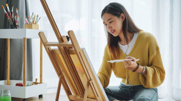 mulher de traços asiáticos pintando uma tela