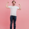 Foto em tamanho real de um homem alegre e sortudo comemorando, isolado sobre um fundo de cor rosa.