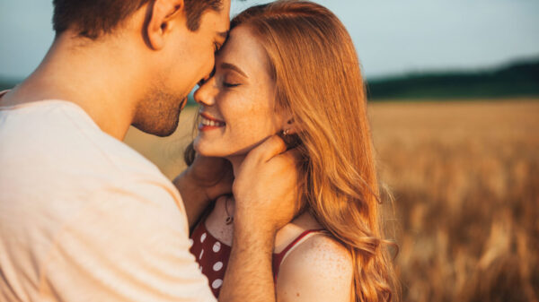 casal sorrindo uma para o outro em um gramada
