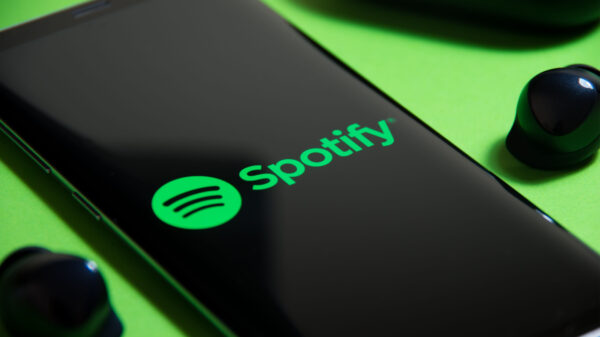 celular aberto o aplicativo do spotify em cima de uma superfície verde