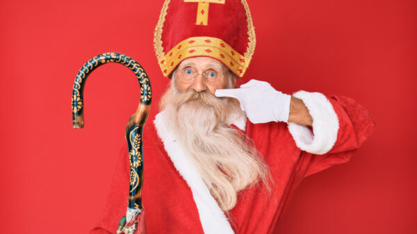 homem velho vestido de papai noel em fundo vermelho