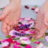 banheira branca com ervas e flores com um par de mãos dentro