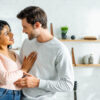 casal em um ambiente semelhante a cozinha de uma casa