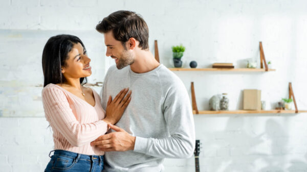 casal em um ambiente semelhante a cozinha de uma casa