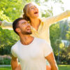 casal feliz e sorridente em um parque florestado