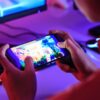 rapaz jogando online no celular em um setup gamer