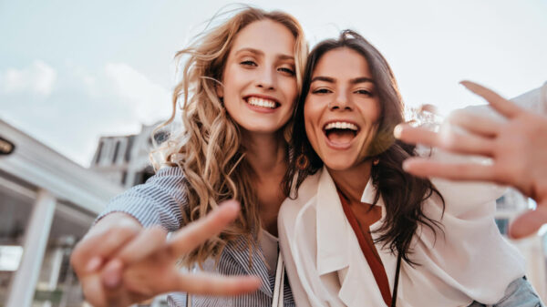 dupla de amigas felizes tirando foto a céu aberto