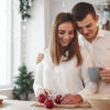 casal hétero vestindo roupa branca e cozinhando juntos
