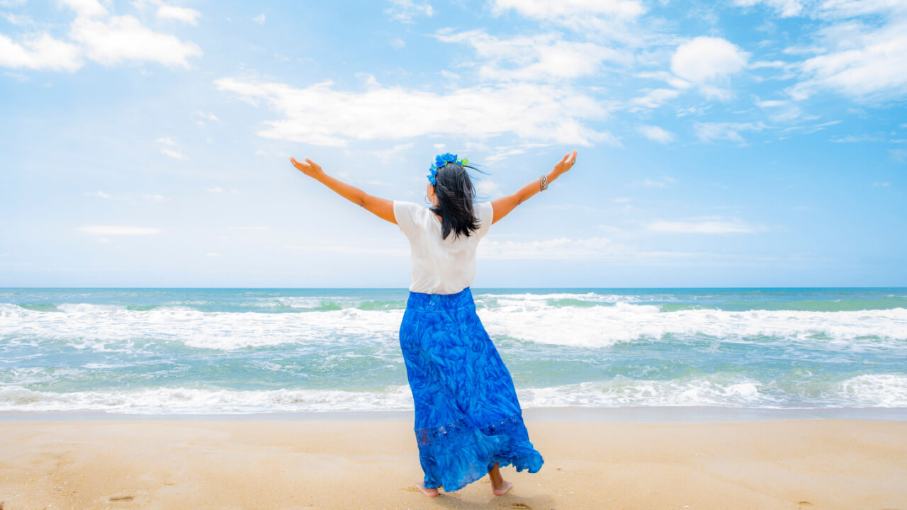 mulher saudando Iemanjá na praia