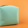 necessaire verde em fundo laranja