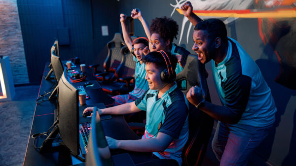na fotografia há um grupo de quatro colegas uniformizados jogando esportes virtuais