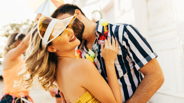 homem beijando o rosto de uma mulher e ambos estão fantasiados para o carnaval