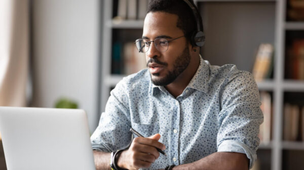 homem com camisa social trabalhando em casa com um notebook prata