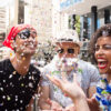 grupo de quatro amigos fantasiados para o carnaval e jogando confetes