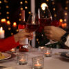 duas taças de vinho brindando em um jantar romantico
