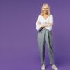 mulher com os braços cruzados em fundo roxo