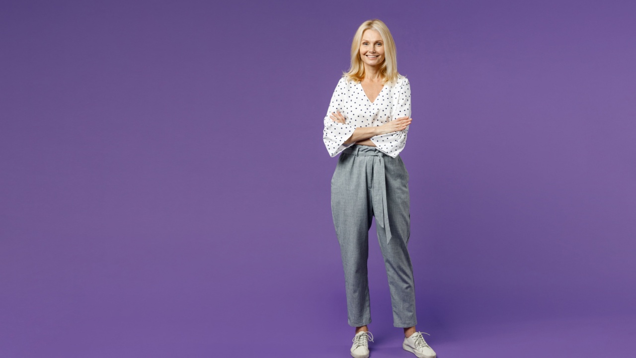 mulher com os braços cruzados em fundo roxo