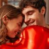 casal abraçado com um balão de coração vermelho na frente