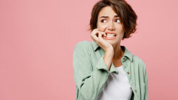 mulher com expressão facial de medo em fundo rosa