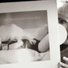 fotografia em preto e branco da cantora taylor swift segurando o disco de vinil do seu álbum the tortured poets department