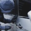 homem tentando abrir a porta de um carro assalto