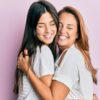 mãe e filha abraçadas em fundo roxo