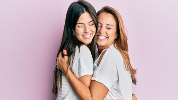 mãe e filha abraçadas em fundo roxo