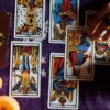 cartas de tarot distribuídas em uma mesa de toalha roxa