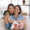 fotografia de mãe e filha se abraçando em um sofá na sala de estar