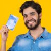 Homem segurando uma carteira de trabalho e previdência social.