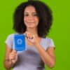 Mulher segurando uma Carteira de Trabalho e Previdência Social.