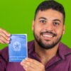Homem segurando uma Carteira de Trabalho e Previdência Social.