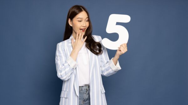 mulher de traços asiáticos segundo o numero cinco branco e grande em fundo azul escuro