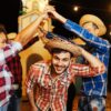 três pessoas de camisa xadrez e brincando de quadrilha de festa junina