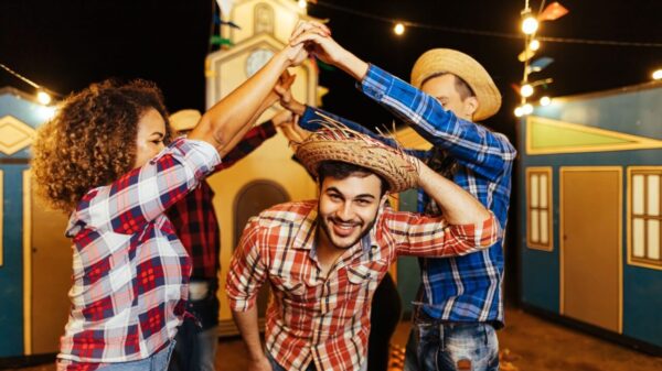 três pessoas de camisa xadrez e brincando de quadrilha de festa junina