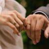 mãos de um casal mostrando a aliança de casamento