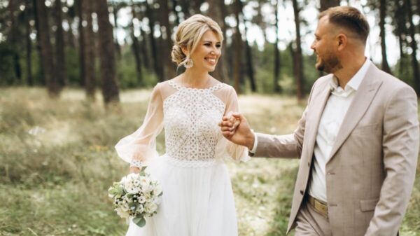 casal de noivos sorrindo em meio à um jardim