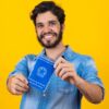 Homem segurando uma Carteira de Trabalho e Previdência Social.