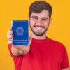 Homem segurando uma Carteira de Trabalho e Previdencia Social.