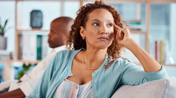 no primeiro plano está uma mulher com cara de desconfiada e em segundo plano um homem