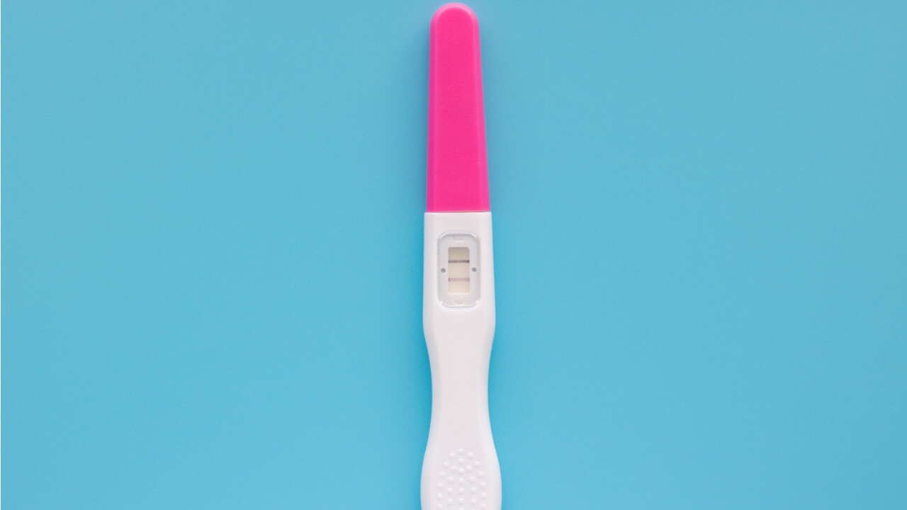 Um teste de gravidez branco isolado em um fundo azul. Conceito de fertilidade e gravidez. Teste com resultado positivo.