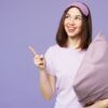 mulher com pijama roxo segurando um travesseiro roxo em fundo roxo