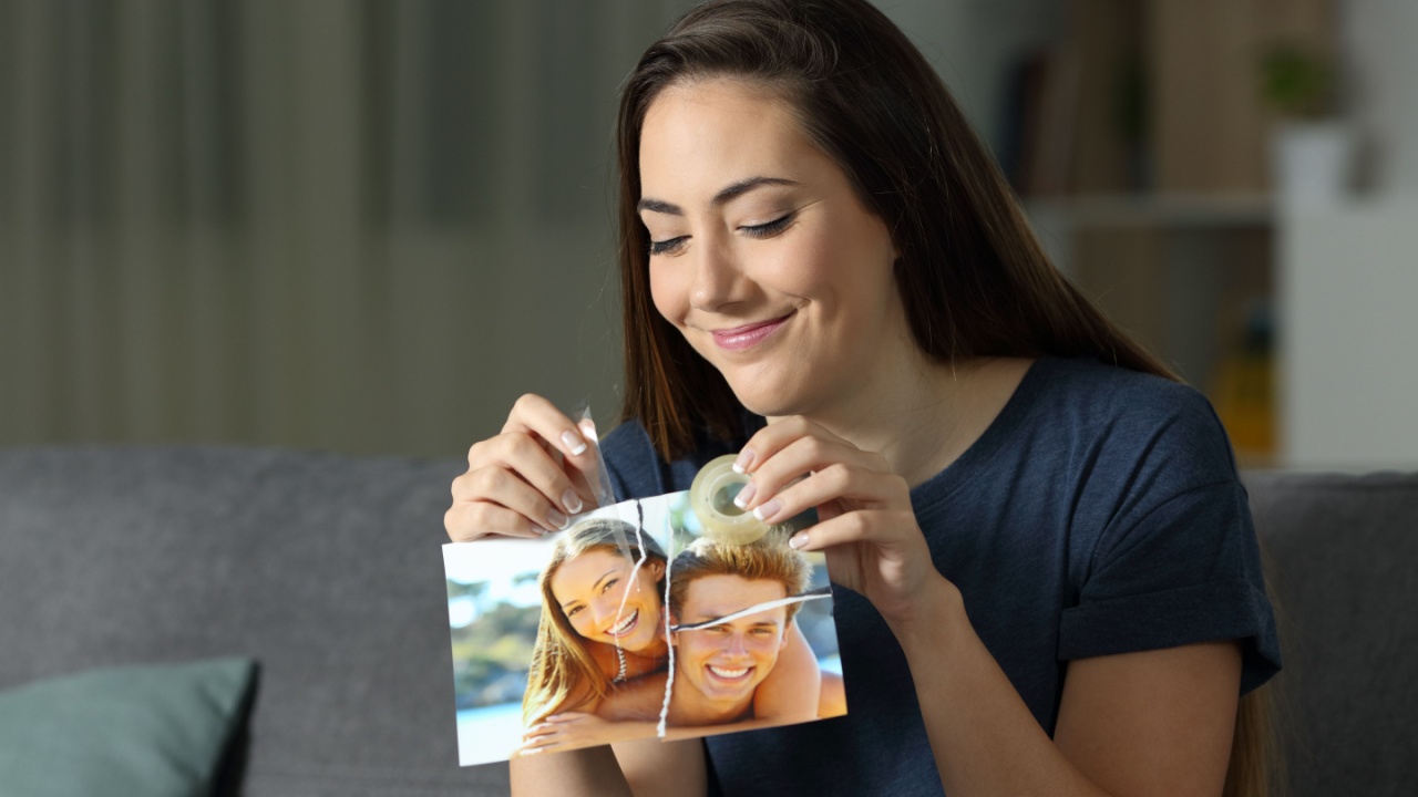 mulher colando com durex os pedaços da foto com o ex