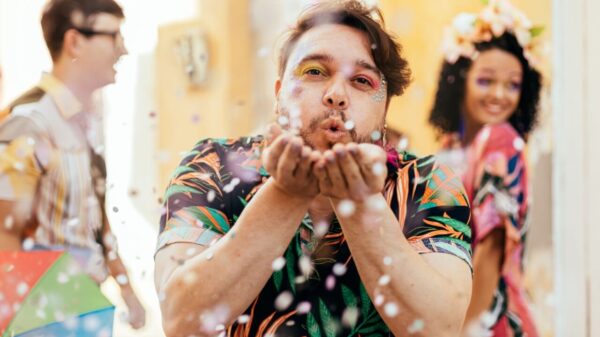 homem assoprando confete em uma festa de carnaval