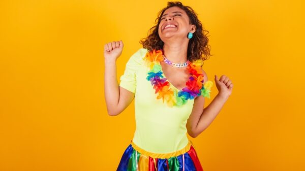 Mulher usando roupas de carnaval, dançando, com um colar de flores.