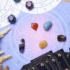 mesa de tarot com cartas, mapa astral e dados