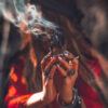 cigana com um maço de ervas defumando em suas mãos
