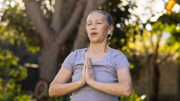 mulher mais velha fazendo ioga ao ar livre em um campo