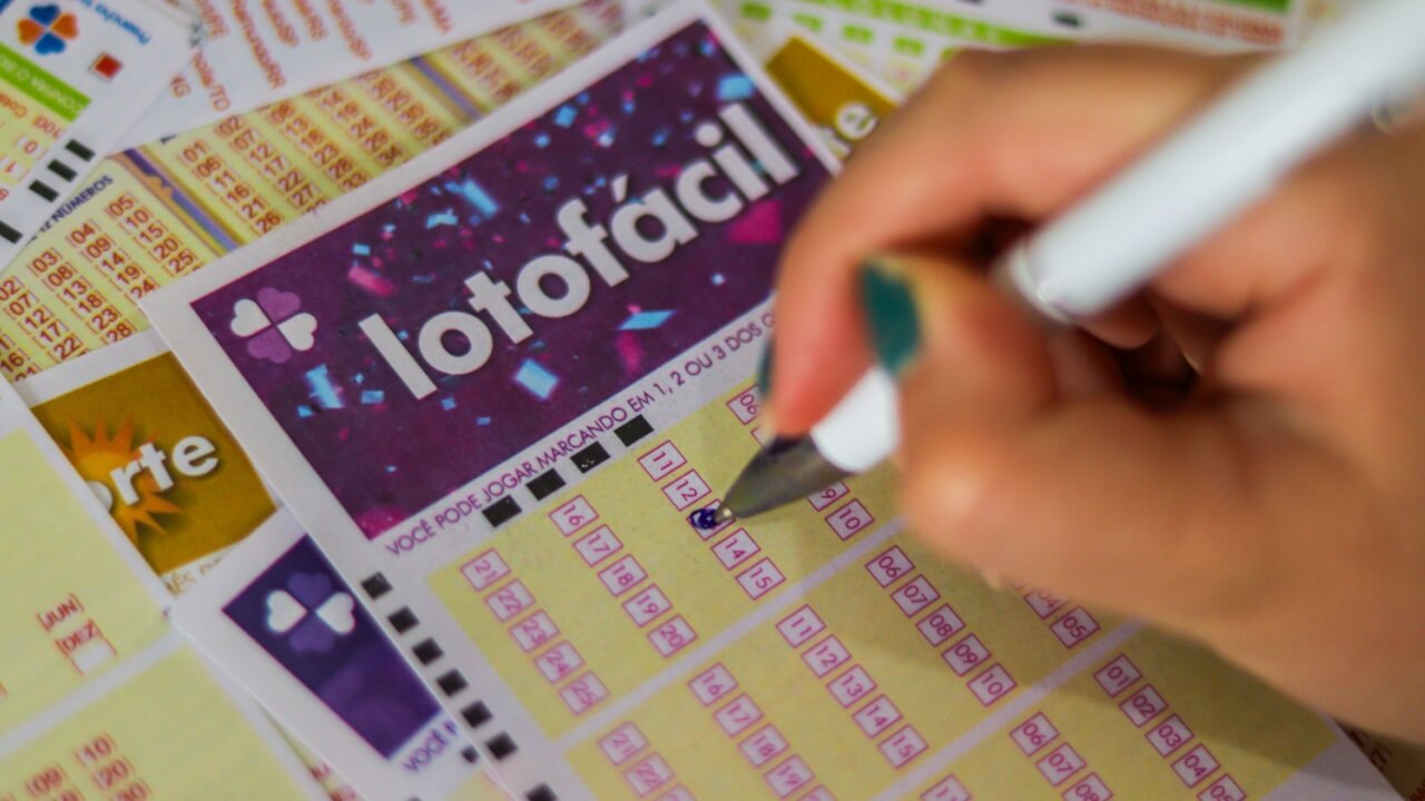 imagem de um bilhete da lotofácil sendo marcado com caneta de tinta azul
